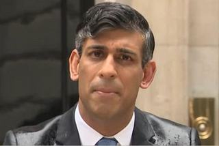Rishi Sunak, the Prime Minsiter of the UK standing in the rain outsode Number 10, announcing the election.