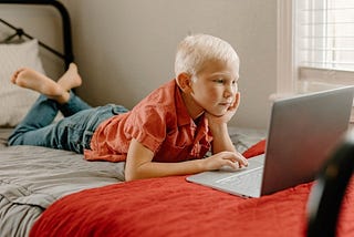Boy on bed with laptop