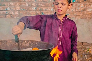 A child roasting corn: shot taken by Noman (Teammate)