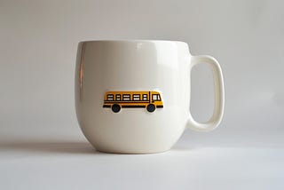A white coffee mug with a picture of a bus on the side