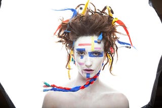 woman in white makeup with wires hanging off her hair and electrical tape on her face — ai vs human intelligent