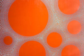 Picture of a painting of orange circles on a background of tiny orange circle outlines