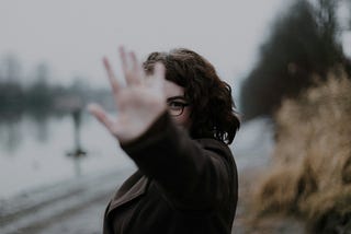 A woman holds up five fingers in front of her face
