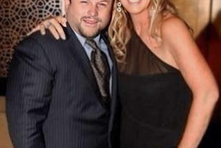 Couple in formal wear. The actor Jason Alexander with a glamorous blonde woman posing for the camera.