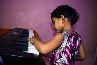 Cute child of color playing the piano
