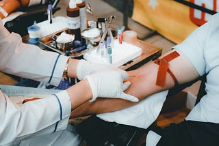 A medical professional putting a needle in a patient’s arm