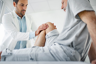 doctor evaluating a man’s knee