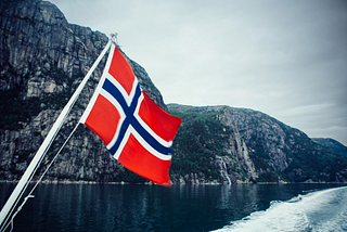 Norwegian flag with an eerie fjord in the background