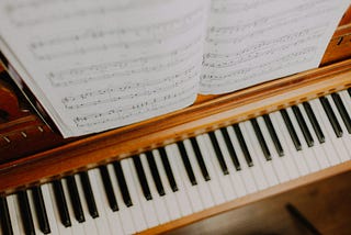 Sheet music set above a piano keyboard