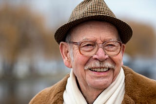 A photo of an old man wearing a herringbone hat.