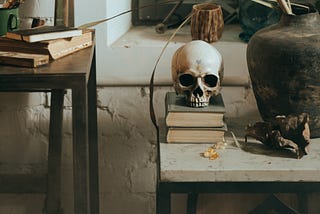 A picture of a skull on a stack of books on a table