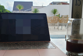 Macbook Air on a glass table in a rooftop cafe in Asia