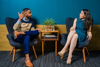 a man and a woman sit discussing