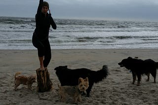 Woman with four dogs at the beach