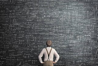 Man looking up at complex scribbles on Blackboard