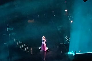 Nicki Minaj alone on stage, looking like a Disney Princess in a pink poofy dress