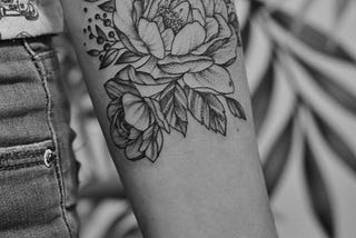 Person’s arm with flower tattoo.