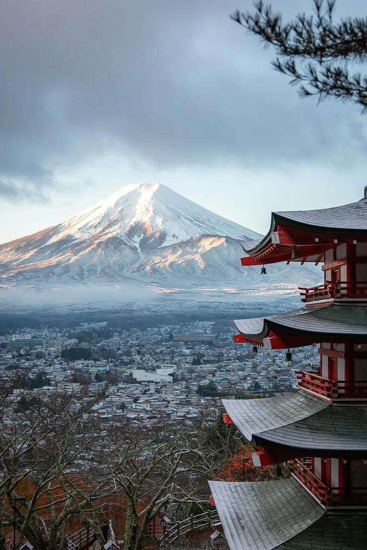Mount Fuji in the background, red Japanese shrine in the foreground.