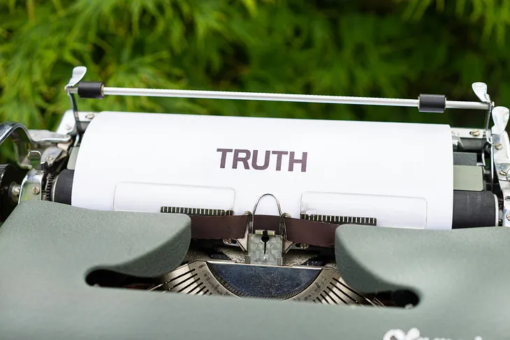 Picture of a typewriter with the word TRUTH printed (but not typed) on the drum.