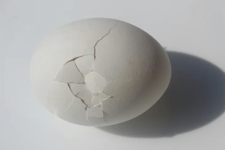 A cracked egg on a white background