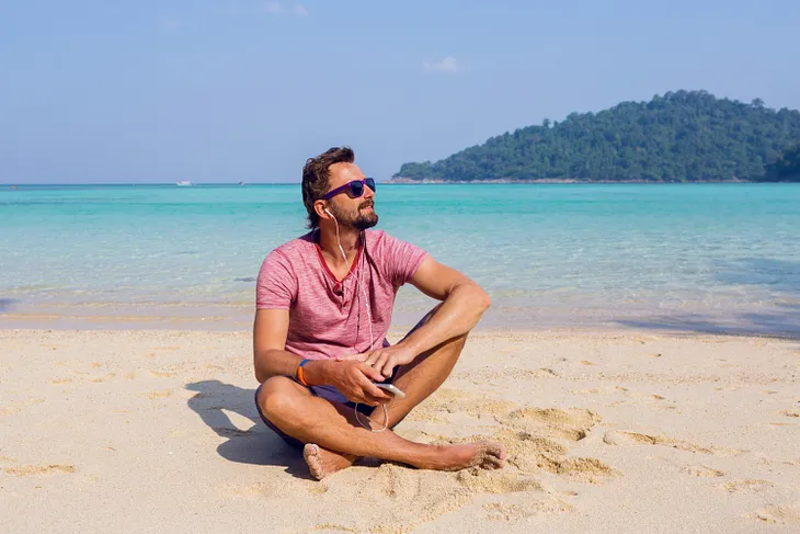 Image of a man relaxing on the beach with mountain views. The Near-Death Experiencer reported seeing similar views when he met an important person (in his life) in heaven.