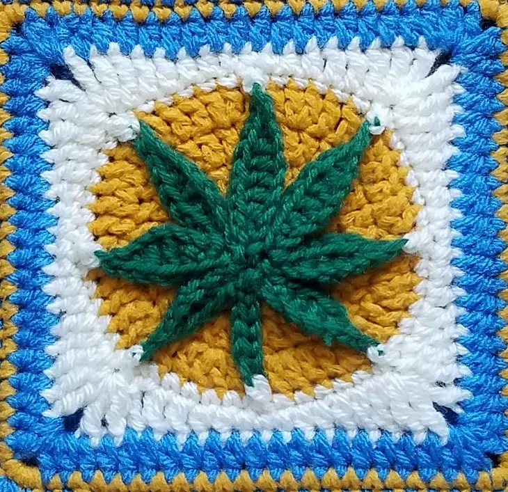 A cannabis leaf crocheted into a square.
